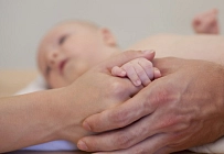Baby in Händen der Eltern