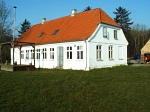 Zu sehen ist das Haupthaus in Lille Bodskovv Dänemark, ein weißes Haus mit rotem Dach.