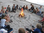 Eine Kindergruppe sitzt um ein Lagerfeuer herum am Strand.
Foto: Nils Schwarz